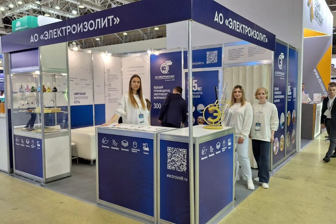 Выставочный стенд АО «Электроизолит»: команда в одинаковых свитшотах с бейджами у стоек с печатью